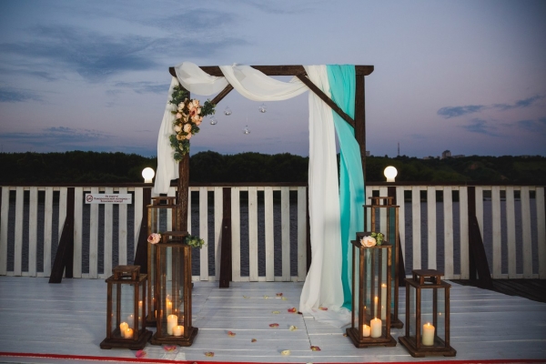 Большая летняя веранда гостинично-развлекательного комплекса «На волне»: свадьба и выездная регистрация на фоне водных пейзажей